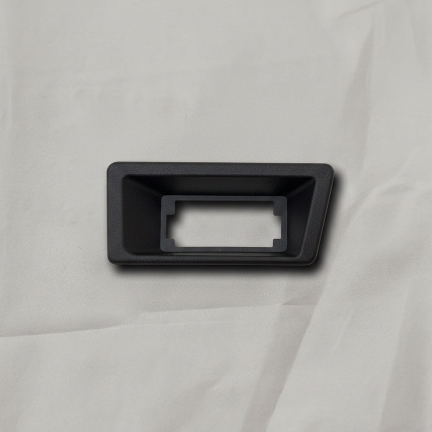 OEM License Plate Lamp Bezel on grey wrinkled craft paper background