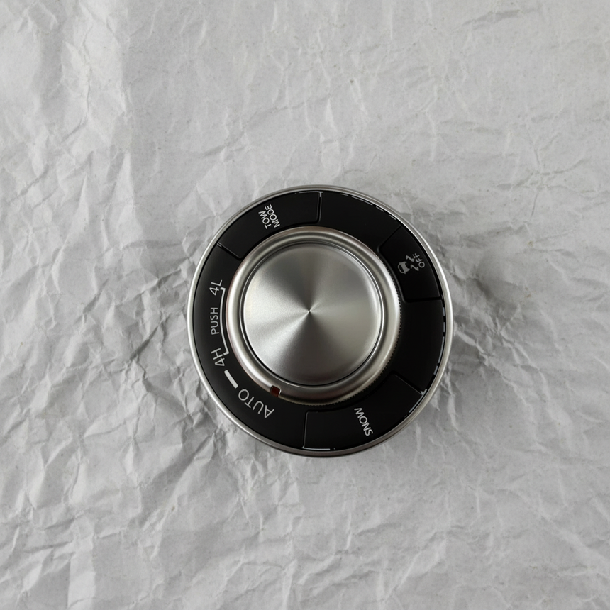 Full view of center control switch AWD on light grey wrinkled kraft paper