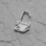 Upper-middle macro crop of torsion spring clip on light grey wrinkled kraft paper background