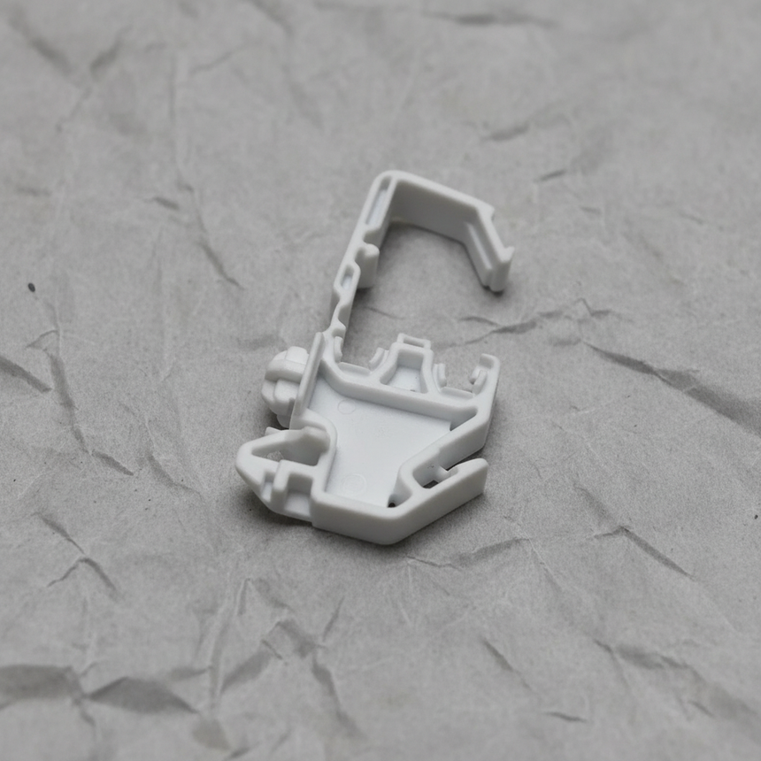 Upper-middle macro crop of torsion spring clip on light grey wrinkled kraft paper background