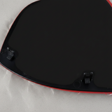 Bottom macro crop of driver side mirror glass angle 2 on light grey wrinkled kraft paper