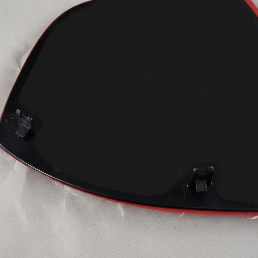 Bottom macro crop of driver side mirror glass angle 2 on light grey wrinkled kraft paper