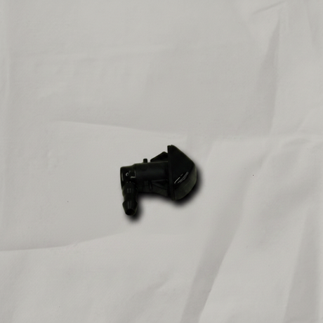 Acura MDX driver side front windshield washer nozzle on light grey wrinkled kraft paper background, packaging removed