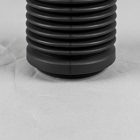Lower-middle macro crop of front suspension strut dust cover on light grey wrinkled kraft paper