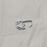 Full view of torsion spring clip on light grey wrinkled kraft paper background