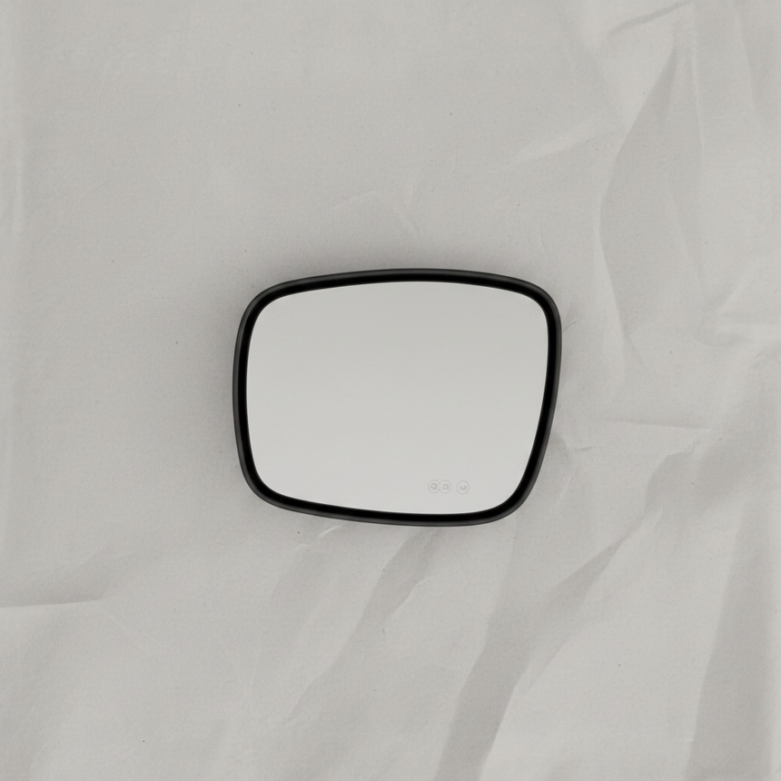 Full view of driver side mirror glass on light grey wrinkled kraft paper