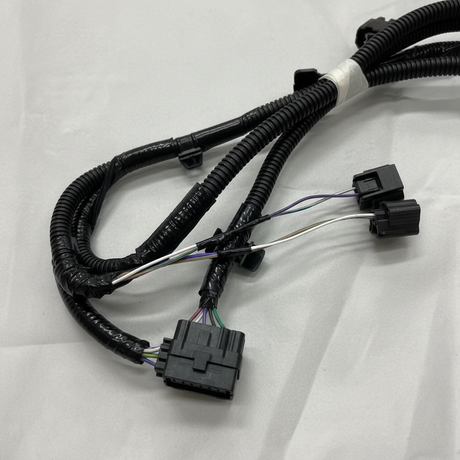 Bottom macro crop of rear park assist camera wiring harness on light grey wrinkled kraft paper