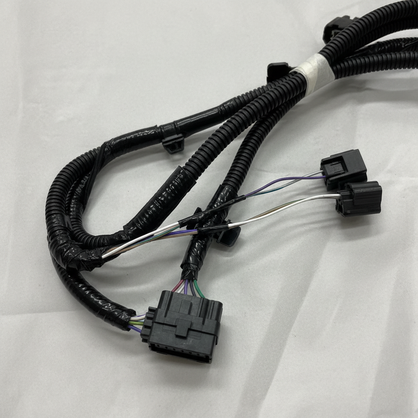 Bottom macro crop of rear park assist camera wiring harness on light grey wrinkled kraft paper
