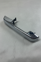 Chrome passenger-side door handle on grey wrinkled craft paper