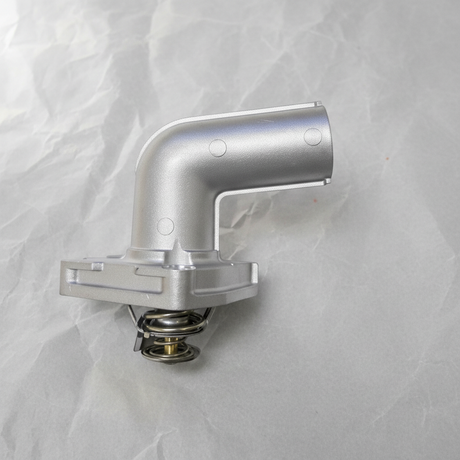 2001-2010 Nissan Altima Maxima Murano Quest 3.5L Thermostat OEM on grey wrinkled craft paper