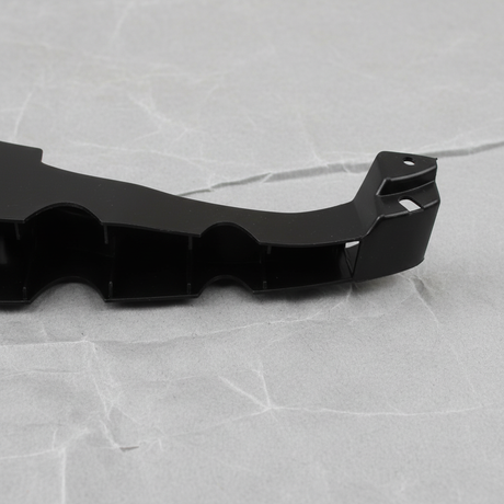 Bottom macro crop of Dodge Charger rear bumper fascia support bracket on light grey wrinkled kraft paper
