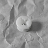 Lower-middle macro crop on light grey wrinkled kraft paper background