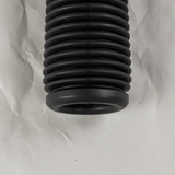 Bottom macro crop of front suspension strut dust cover on light grey wrinkled kraft paper