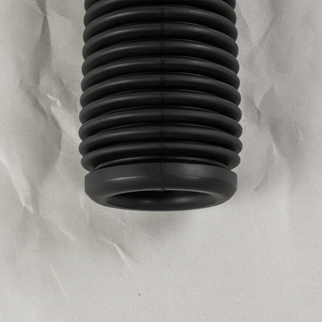 Bottom macro crop of front suspension strut dust cover on light grey wrinkled kraft paper