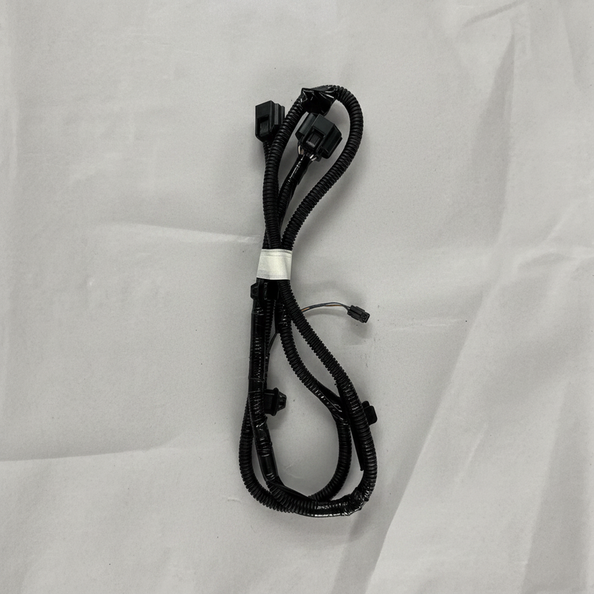 Full view of rear park assist camera wiring harness on light grey wrinkled kraft paper