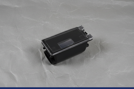 2016-2025 Ford Rear License Plate Lamp Light Housing Genuine OEM - Rotated 27 degrees on gray kraft paper background with blue line