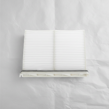 Full view of Mazda CX-9 cabin air filter on light grey wrinkled kraft paper