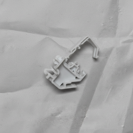 Lower-middle macro crop of torsion spring clip on light grey wrinkled kraft paper background