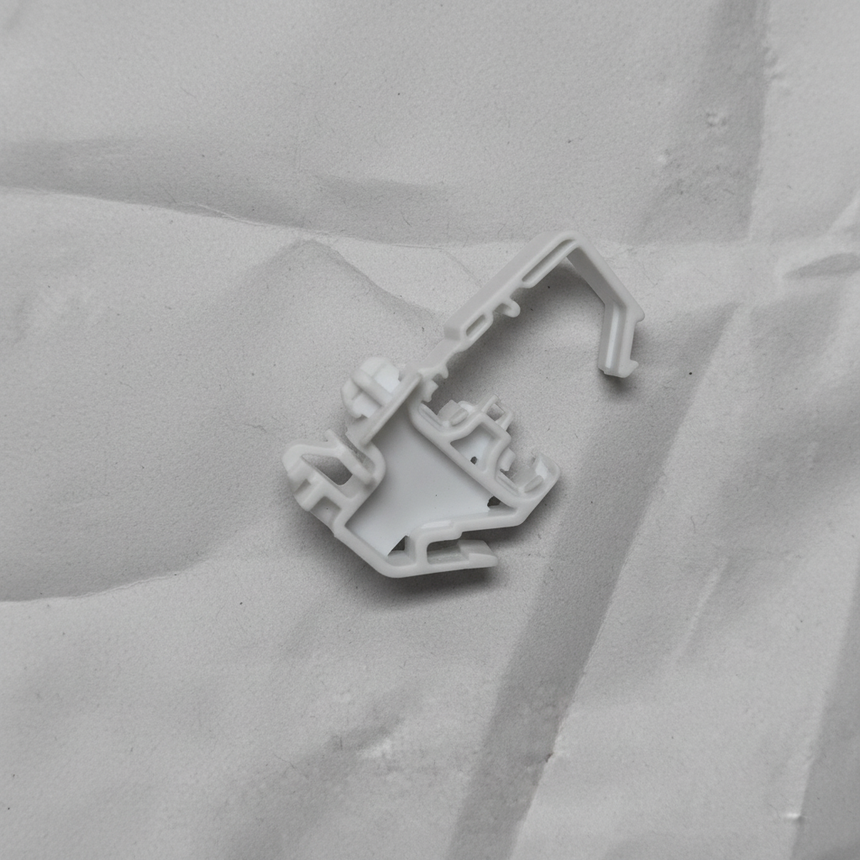 Lower-middle macro crop of torsion spring clip on light grey wrinkled kraft paper background