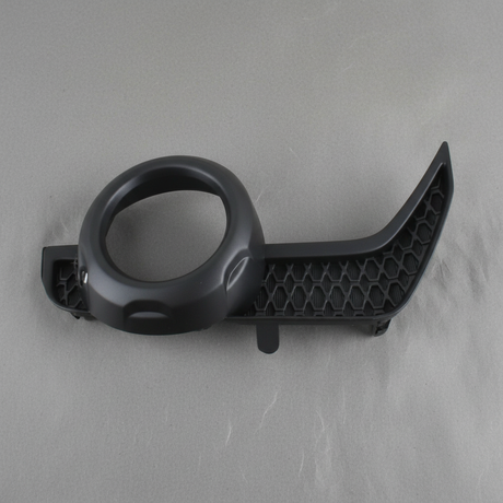 2014-2021 Toyota 4Runner Driver Side Front Fog Light Trim Genuine OEM - rotated 30 degrees on kraft paper background