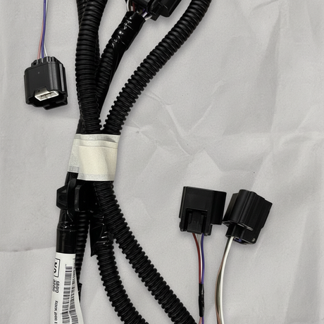 Lower-middle macro crop of rear park assist camera wiring harness on light grey wrinkled kraft paper