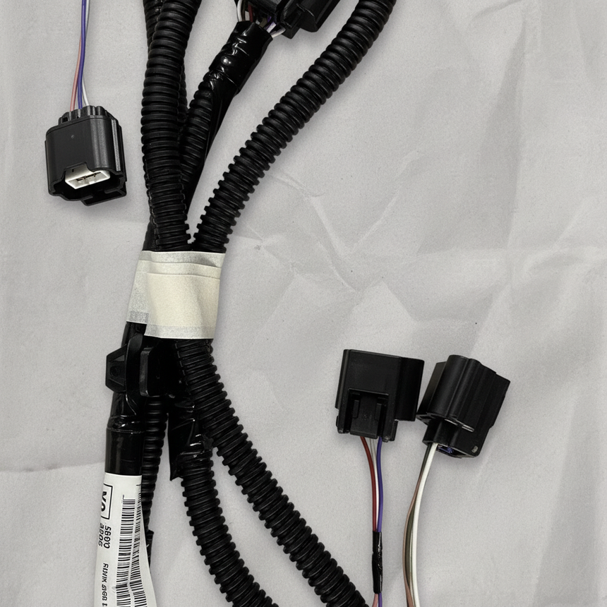 Lower-middle macro crop of rear park assist camera wiring harness on light grey wrinkled kraft paper