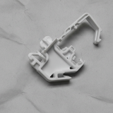 Bottom macro crop of torsion spring clip on light grey wrinkled kraft paper background