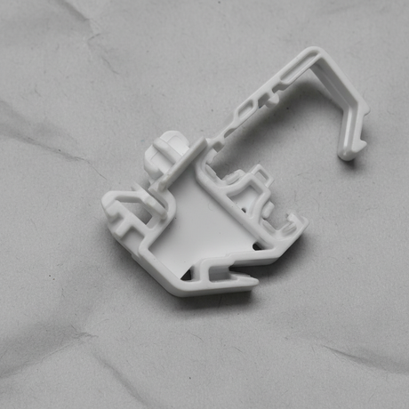 Bottom macro crop of torsion spring clip on light grey wrinkled kraft paper background