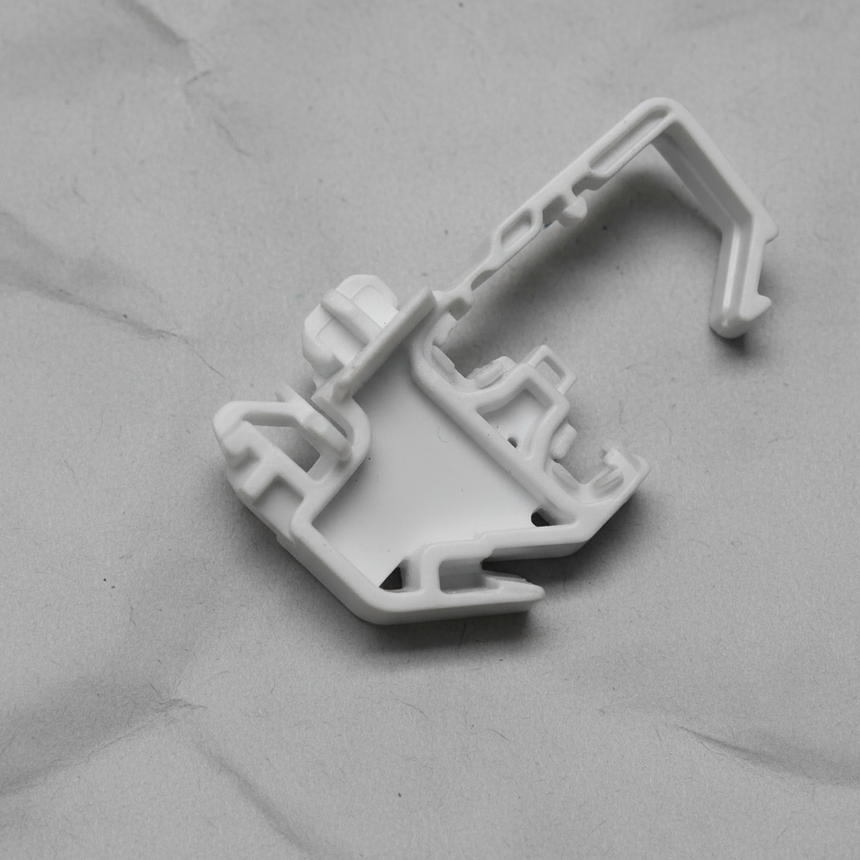 Bottom macro crop of torsion spring clip on light grey wrinkled kraft paper background