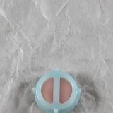 Top macro crop of brake master cylinder reservoir strainer on light grey wrinkled kraft paper