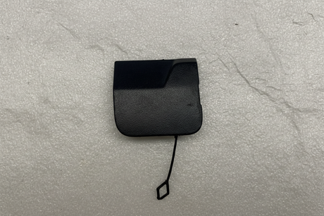 2021-25 Silverado Tahoe Escalade Rear Bumper Tow Eye Cap OEM on grey kraft paper background