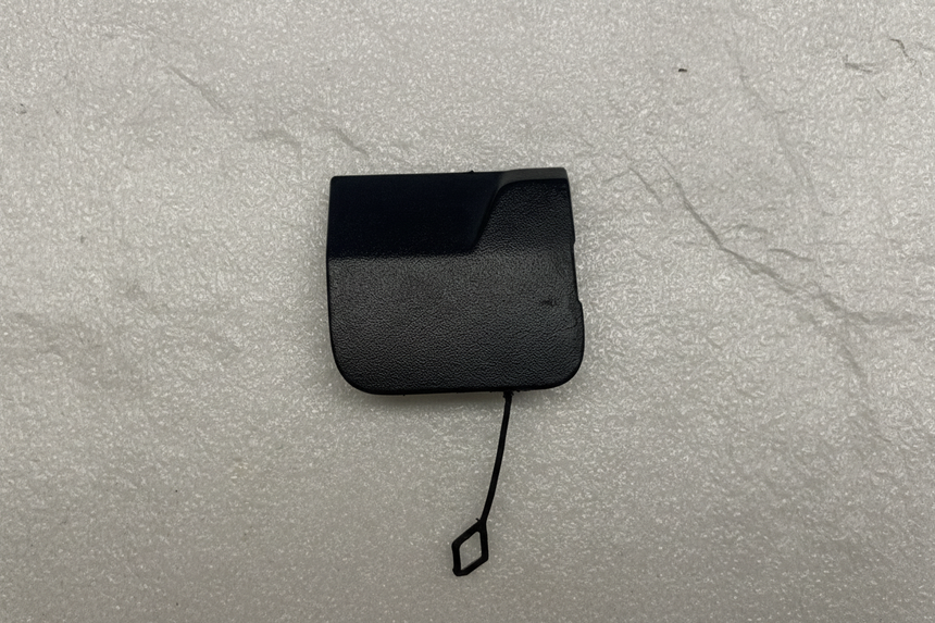2021-25 Silverado Tahoe Escalade Rear Bumper Tow Eye Cap OEM on grey kraft paper background