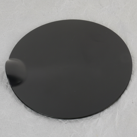 Middle macro crop of Ford F-150 fuel tank filler door on light grey wrinkled kraft paper