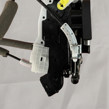 Lower-middle macro crop of door lock actuator motor on light grey wrinkled kraft paper