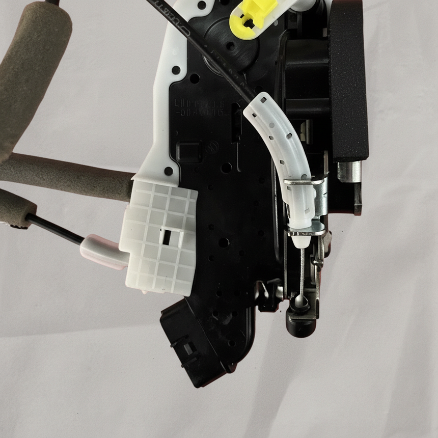 Lower-middle macro crop of door lock actuator motor on light grey wrinkled kraft paper